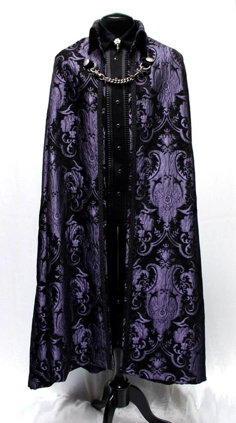 "A magnificent cape fit for royalty. Made in rich flowing black and gold tapestry fabric with rich black satin lining inside. The high pointed collar can be worn down or up for an extra dramatic effect. Braided black trim lines the collar and along the front of cape. Fully lined in rich black satin. Fastens in front with a heavy antiqued chain which clasp at either side to heavy D-rings and decorated with two ornate metal buttons. Slits in the front of cape allow the wearer to reach through and Wizard Aesthetic Outfit, Fantasy Suit, Prince Cape, Purple Cape, Black Tapestry, Black Cloak, Gold Tapestry, King Outfit, Purple Suits