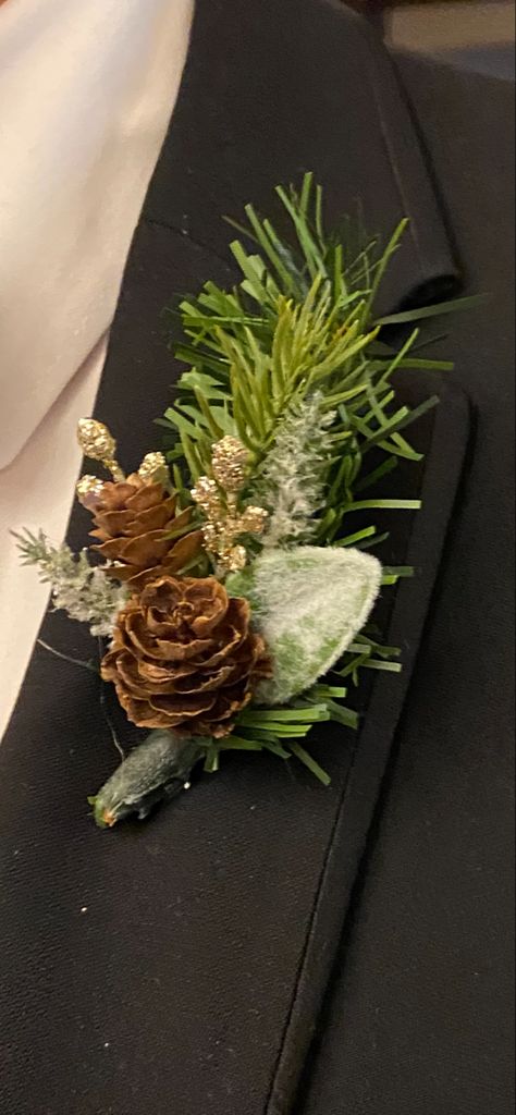 Winter/Christmas wedding boutonniere. Greens and pinecones Created by certain event designs Winter Wedding Boutineer Grooms, Winter Greenery Boutonniere, Evergreen Boutonniere, Pinecone Wedding Decorations, Winter Wedding Pinecones, Winter Pine Bouquet, Winter Wedding Pine Tree Decor, Snowflake Wedding Theme, Winter Christmas Wedding