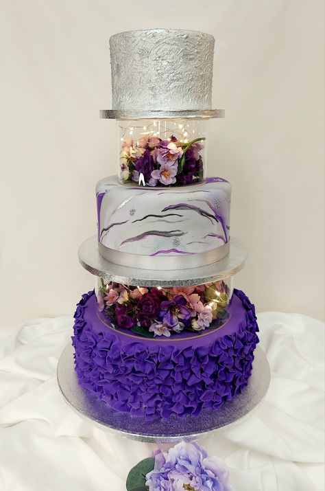 3-tier wedding cake with acrylic separator boxes filled with flowers and lights. This cake has a combination of tiers iced in buttercream and fondant. #weddingcakes #purple #silver #25thanniversary #adcbakery #jacksonvillenc Cakes With Acrylic Tier, Acrylic Cake Separator, Purple Tiered Cake, Cake With Acrylic Separator, Wedding Cake Silver, 3 Tier Birthday Cake, Sparkly Wedding Cakes, Cakes Without Fondant, Tire Cake