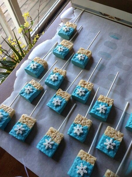 Frozen themed rice crispy treats Frozen Treats Disney, Winter Theme Party Snacks, Disney Frozen Themed Food, Frozen Themed Birthday Party Treats, Frozen Themed Snacks For Kids, Frozen Party Treats Ideas, Frozen Disney Desserts, Frozen Candy Table Ideas, Frozen Themed Dessert Table