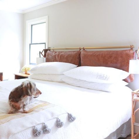 a neutral and serene space done with a brown leather pillow headboard on a brass holder that adds color and texture Headboard Pillows, Headboard Cushion, Vintage Inspired Bedroom, Boho Headboard, Pillow Headboard, Custom Bench, Peaceful Bedroom, Bright Pillows, Hanging Bedroom