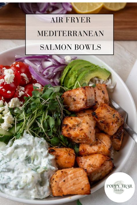 A large shallow bowl holds air fryer Mediterranean salmon bowls. The dish is garnished with bright vegetables and tzatziki sauce.  A wooden board with more chopped vegetables sit near the bowl. Salmon Tzatziki Bowl, Mediterranean Salmon Bowl, Mediterranean Diet Salmon, Salmon Meals, Fancy Meals, Salmon Bowls, Weekend Meal Prep, Mediterranean Salmon, Mediterranean Bowls