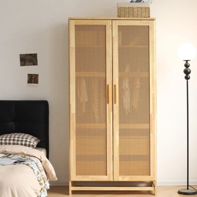 Crafted with solid pine wood and featuring two rattan doors and two interior drawers at the bottom, this closet is perfect for storing your clothes and other items. Create a cozy and stylish atmosphere in your bedroom with this unique Pine Wood Closet. The wood handles add a classic touch to the design, while the natural tone of the wood creates a warm and inviting look. With plenty of space to store your clothing and accessories, this closet is the perfect addition to any bedroom. Bay Isle Home Solid Wood Armoire, Rattan Doors, Solid Wood Wardrobes, Wood Closet, Wood Armoire, Bedroom Upgrade, Wood Wardrobe, Bedroom Armoire, Wood Handles