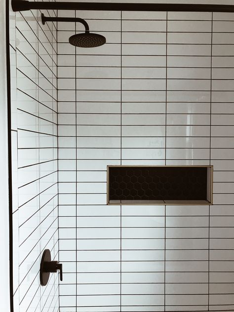 Brass schluter on honeycomb black niche with stacker long skinny subway tile and matte black fixtures Large White Subway Tile Bathroom, Horizontal Stacked Subway Tile, Black Subway Tile Bathroom, Stacked Subway Tile Bathroom, Corporate Bathroom, Brass Schluter, Cooper Bathroom, White Subway Tile Bathroom, Shower Pan Tile