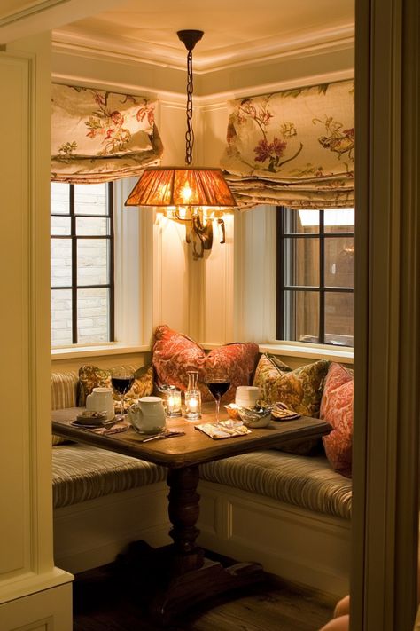 Cozy restaurant nook with a wooden table set for two, featuring floral curtains and a warm, hanging light fixture. Dining Alcove Kitchen Nook, Breakfast Nook Booth Seating, Corner Window Nook, Library Breakfast Nook, Wallpaper Kitchen Nook, French Breakfast Nook, Breakfast Nook Booth, Breakfast Nook Corner, Breakfast Nooks Ideas