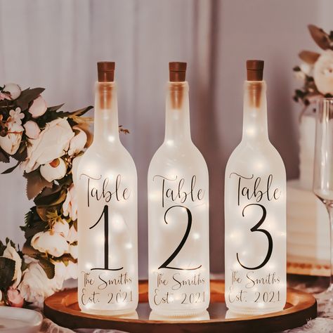 Wedding Table Numbers - Event Table Centerpieces - Vineyard Wedding Decor - Garden Wedding Decor - Wine Bottle Lights - Rehearsal Dinner | MakerPlace by Michaels Wine Bottle Table Numbers Wedding, Unique Wedding Table Numbers, Light Up Wine Bottles, Simple Wedding Table Decorations, Wine Bottle Wedding Centerpieces, Unique Table Numbers Wedding, Wine Bottle Wedding, Vineyard Wedding Decor, Led Lights Wedding