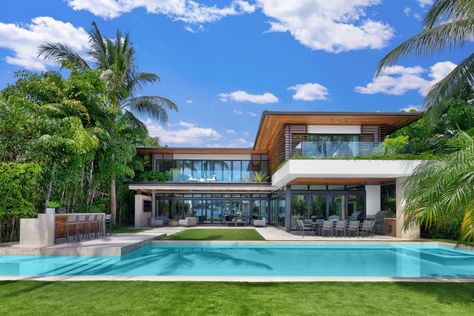 A waterfront mansion on Miami Beach’s Sunset Islands has sold for $32 million. Features include natural honed limestone and oak flooring, custom millwork, a fireplace room and a dining area with a wine cellar, plus an office overlooking a koi pond and floating gardens. Outside, there’s a covered media lounge, a knife-edged pool, a wet bar, a summer kitchen and a guest pavilion, the listing said. Contemporary Architecture House, Miami Beach Mansion, Bel Air Road, Bel Air Mansion, Fire Pit Seating Area, Modern Miami, Living Pool, Los Angeles Skyline, Expensive Houses