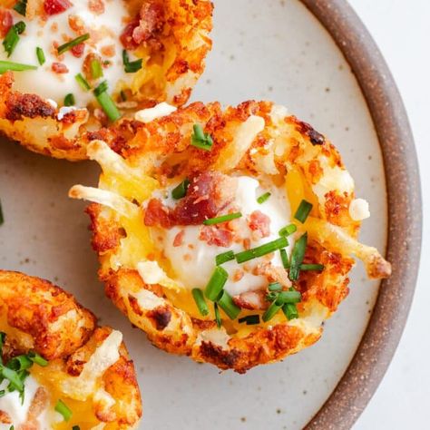 These Loaded Tater Tot Cups have all the best toppings of a baked potato in a delicious tater tot appetizer! Topped with cheese, sour cream, bacon, and chives, they are ready in just 30 minutes. Gluten-free with dairy-free and vegan options. Tater Tot Cups, Tater Tot Recipe, Tater Tot Appetizers, Loaded Tater Tot, Loaded Tater Tots, Vegan Bacon Bits, Tater Tot Recipes, Appetizer Cups, Vegan Bacon