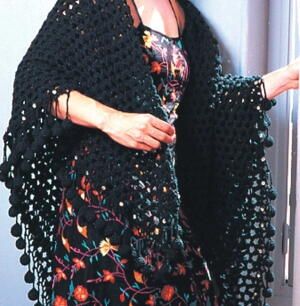 If you're looking for witchy crochet patterns, this lovely black shawl in an openwork pattern with fun crochet ball trim is for you. This crochet shawl is a great way to wrap up in the evenings or dress up for an afternoon outing. It's spooky enough to be a part of your witch costume this Halloween but classy enough to wear throughout the year. You could even crochet this pattern in a variety of colors for a totally different vibe. You're not going to want to miss out on this beautiful and uniqu Crochet Ruana, Mesh Shawl, Ruana Pattern, Wearable Crochet, Crocheted Shawls, Diy Shawl, Crochet Wraps, Crochet Wrap Pattern, Crochet Black