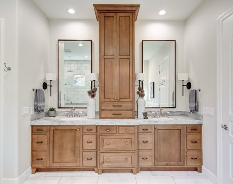 Master Bath Vanity With Middle Tower, Double Bathroom Vanity With Storage Tower, Double Vanity Linen Tower, Bathroom Vanity Towel Storage, Updated Jack And Jill Bathroom, Master Bath Stained Cabinets, Bathroom Vanity With Tall Cabinet In Middle, Primary Bathroom Cabinet Ideas, Double Vanity With Storage In The Middle