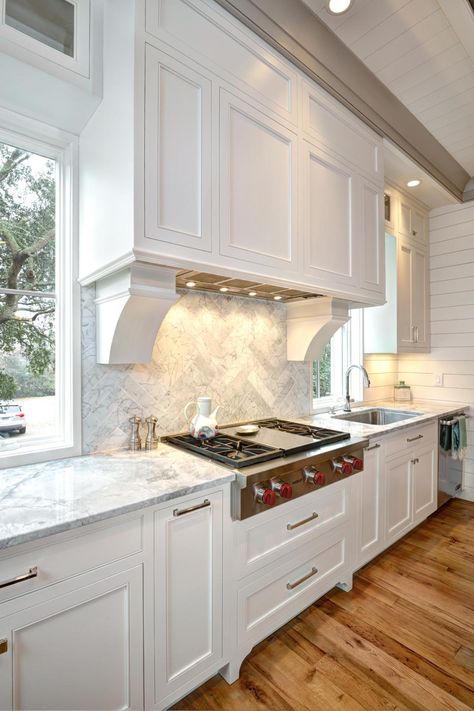 White, bright and airy: This coastal-style kitchen is a cook's dream! From the understated range hood to the reclaimed wood floors to the beautiful, herringbone-patterned marble backsplash, there's so much to love. Lofty ceilings add to the sense of space in the room. Kitchen Remodel Trends, Coastal Style Kitchen, Kitchen Hood, Kitchen Hoods, Painting Kitchen, White Kitchen Design, White Kitchens, Classic Kitchen, Built In Cabinets