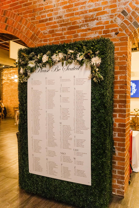 The Finks opted for a large seating chart installation on their custom boxwood hedge wall pairing it with a floral garland for the perfect display of guest names. Seating Chart by @artfullyoverjoyed #weddingstationery #dayofstationery #stlouiswedding #guestseatingchart #escortchart #boxwoodhedgewall #seatingchartinspiration #elegantwedding #classicwedding Boxwood Wall Seating Chart, Greenery Seating Chart, Boxwood Seating Chart, Greenery Wall Seating Chart, Wall Seating Chart, Large Seating Chart, Boxwood Wall, Boxwood Hedge Wall, Hedge Wall