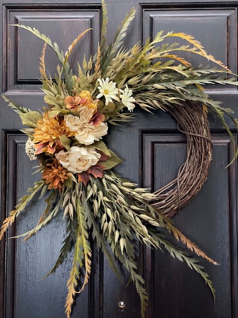 Bring the feeling of fall into your home with this wreath composed of mountain fern, oat seeds, peonies, hydrangeas, dahlias, and petite berries. This wreath features a mix of beige, brown, and green colors for a more realistic fall look. Add this piece to your front door or your wall for a look inspired by autumn this season.  [ Measurements ] Height: 25 in Width: 20 in Depth: 6 in Fall Decor Floral, Fall Wreath With Velvet Ribbon, Fall Boho Wreath, Minimalist Fall Wreath, Autumnal Wreaths, Fall Wreath Ideas Diy, Modern Fall Wreath, Cabin Wreath, Wreath With Initial