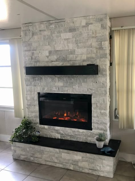 DIY Fireplace with Ledger Stone White Stone Fireplace With Black Mantle, Tile And Stone Fireplace, Light Gray Stone Fireplace, Stone Fireplace With Black Mantle, Black And White Stone Fireplace, Black And White Chimney, Grey Stacked Stone Fireplace, Electric Fireplace Ideas With Stone, Stone Ledger Fireplace