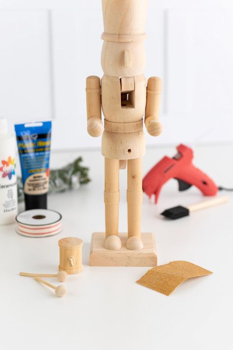 unfinished wooden nutcracker and craft supplies to make a DIY modern nutcracker Michaels Wooden Nutcracker, Nut Cracker Diy Painting, How To Paint A Wooden Nutcracker, Nutcracker Diy Painting, Hand Painted Nutcracker Diy, Wooden Nutcracker Painting Ideas, Painted Nutcracker Diy, Modern Nutcracker, Diy Nutcracker