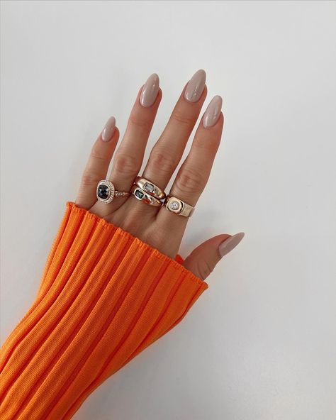 Hand with grey beige nails and gold rings wearing an orange top Ttpd Inspired Nails, Greige Nails, Nail Designs For Fall, Purple Chrome Nails, Fall Purple, Fall Nail Ideas, Fall Nail Trends, Floral Nail Designs, Beauty Magic