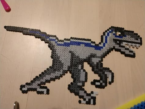 blue jurassic park perler dinosaur Jurassic Park Perler Beads, Perler Dinosaur, Dinosaur Perler Bead Pattern, Dinosaur Perler Beads, Dinosaur Pixel Art, Hamma Beads Ideas, Moon Cross Stitch, Indominus Rex, Melty Bead Patterns