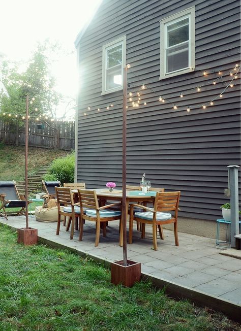 I've always loved the look of bistro lights in outdoor spaces, but our patio didn't have anywhere to to attach the string lights. But now it does! Click through to find out how to make your own cement box-mounted posts to attach your string lights to. #Curbly-Original, #How-To, #DIY, #patio, #backyard, #entertaining, #deck Diy Outdoor Lights, Light Posts, Small Patio Design, Diy Outdoor Lighting, Outdoor Lighting Ideas, Patio String Lights, Bistro Lights, Cheap Patio, Patio Lights