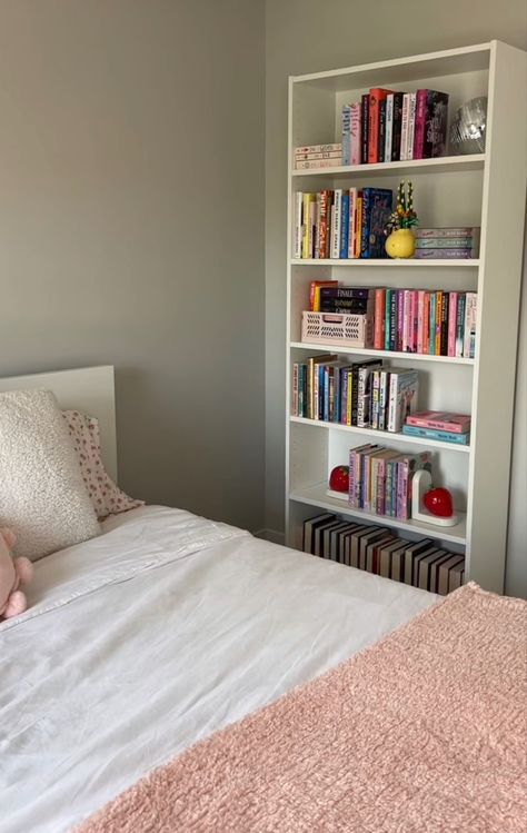 White book shelf filled with books and cute decor next to a bed with white bedding and a pink blanket on top. Bookshelf Inspo, White Bookshelf, Bookshelf Inspiration, Bookshelves In Bedroom, Rustic Retreat, Room Deco, Cozy Room Decor, Dream Room Inspiration, Room Makeover Bedroom