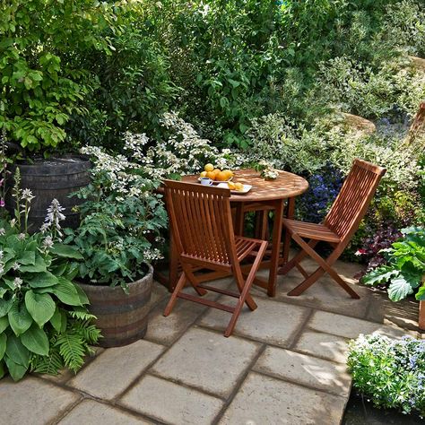 A patio table and chair in a small garden Small Garden Table And Chairs, Small Outdoor Table, Garden Sitting Areas, Small Table And Chairs, Vertical Vegetable Garden, Cozy Backyard, Garden Table And Chairs, Large Backyard, Small Backyard Landscaping