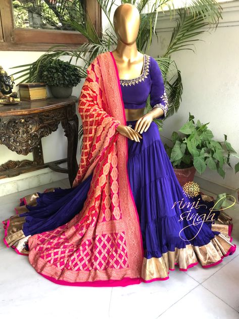 "Inspiration is some mysterious blessing which happens when the wheels are turning smoothly." Purple gypsy lehenga in chinnon chiffon, teamed with a matching crepe choli and a two shade banarasi rai bandhani dupatta with zari in pure georgette. There is dabka and kundan hand embroidery on the neckline, sleeve and waist of the lehenga. Available exclusively at Rimi Singh Studio A 999 Sushant Lok 1 Gurgaon #9818310054. Bandni Dupatta Lehenga, Bandhani Dupatta Outfit, Summer Color Combos, Bandhani Dupatta, Choli Dress, Navratri Dress, 40 Fashion Women, Wedding Lehenga Designs, Kurti Embroidery Design