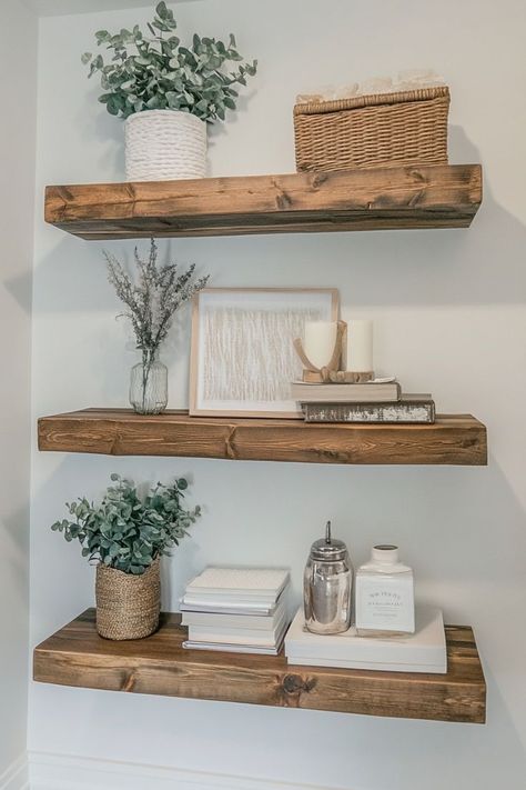 Use floating shelves to display aesthetically pleasing decor like candles, books, plants, and small framed art. To maintain a minimalist look, style the shelves with a limited number of items and ensure each piece complements the others in color and style. Great for living rooms, bedrooms, or kitchens.🛋✨ #FloatingShelves #StyledShelves #MinimalistDecor Wall Shelf Living Room Decor, Decorations For Floating Shelves, Floating Shelves Placement Ideas, White Floating Shelves Living Room, Shelf Decor Living Room Wall Shelves, Floating Shelves Arrangement, Floating Shelf Decor Bedroom, Kitchen Floating Shelves Decor Ideas, Floating Shelf Decor Living Room