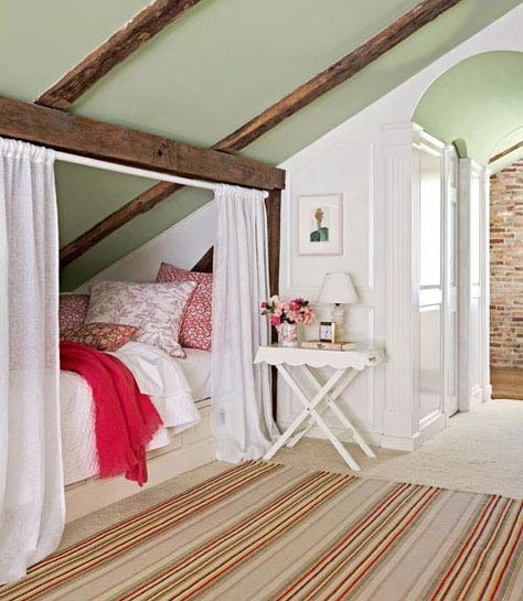 Hideaway Bed--Create a private hideaway with a simple tension rod and curtains. This super cozy sleeping nook, framed by the home’s original wood beams features bedding by John Robshaw, complimented by a striped rug from Dash & Albert. Small Attic Bedroom, Green Ceiling, Hideaway Bed, Sleeping Nook, Small Kids Room, Hidden Bed, Small Attic, Attic Bedrooms, Attic Renovation