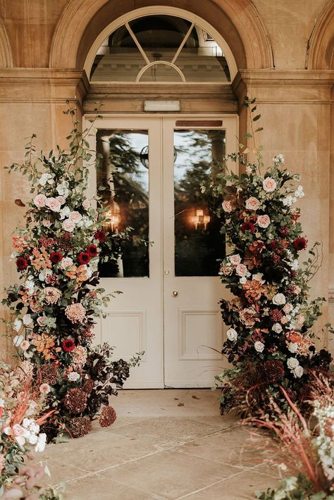 Pale pink and red autumnal wedding flower column decorations Fall Flower Arch Wedding, Rusty Red Wedding, Ballroom Wedding Flowers, Blush Autumn Wedding, Classy October Wedding, Wedding Flower Columns, Rust Floral Arrangement, Moody Wedding Ceremony Decor, Fall Floral Arch Wedding