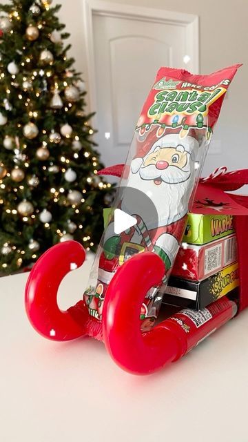 Emma Villaneda on Instagram: "🎄Pt.2 of Dollar Tree gift ideas for teachers, neighbors, coworkers, family/friends, or really anyone. 🎁🎁🎁 Sharing a fun way to gift candy! Make sure you follow for more so you don’t miss out! Materials: - 2 filled Candy Canes (Dollar Tree) - 3 candy boxes (Dollar Tree) - Chocolate Santa (Dollar Tree) - Ribbon • • • • #christmas #christmasdecor #santaclaus #sleigh #christmasgift #gingerbread #christmastime #holiday #holidaydecor #diy #craft #homedecor #design #home #interior #homedesign #interiordesign #gift #giftideas #explorepage #trending #reelvideo #newreel #art #dollartree #dollarstore #creative #santa #chocolate #candy" Boxed Candy Gift Ideas, Candy Christmas Sleighs, Candy Sleigh Gift Card Holder, Santa Sleigh Candy Diy, Christmas Candy Sled Ideas, Chocolate Bar Sled Candy Sleigh, Sleighs Made Out Of Candy, Candy Bouquet Christmas Diy, Candy Cane Sleds Christmas