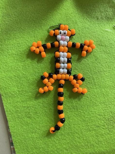 Tiger Bead Pet. Lay out the beads in this pattern. We used drinking straws cut lengthwise to put the beads on each row, then cut the straw to the length needed. Straws will not even show. Lace together Tiger starting with top of head to feet using a tapestry needle. We finished the tail separately and then attahed it. See all Pinterest patterns at: "Bead Pets on Steroids" and https://www.youtube.com/channel/UC5rlDi0oy7YoVMcdNeaTpIw/videos. Tri Bead Crafts, Bead Pets Pattern Diy Tutorial, 90s Bead Animals, Bead Pets Pattern Easy, How To Make Beaded Animal Keychains, Pony Bead Animals Patterns, Bead Pets Pattern, Pony Bead Patterns Easy, Bead Animals Patterns Easy