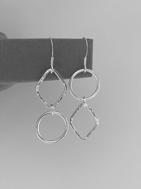 Beautiful mismatched sterling silver earrings, handmade by Verve Jewellery.   Available as a stud or as a dangle, these striking statement earrings are handcrafted using sterling silver wire, and are designed with a subtle asymmetry that really catches the eye.  Each rhombus shape has been hammer textured to catch the light as you move and each shape is independent of each other allowing for fluidity and free movement.  The asymmetric earrings measure at approximately 4cm in length, with a total drop length of 5.5cm for the dangle earrings.  These asymmetrical earrings are sent in a beautiful presentation box, ready to give as a gift or just to treat yourself. The mismatched earrings are handmade by Verve Jewellery.  I do take custom orders so if you would like to amend this design in any Asymmetric Earrings, Sterling Silver Earrings Handmade, Square Jewelry, Rhombus Shape, Asymmetrical Earrings, Free Movement, Silver Earrings Handmade, Mismatched Earrings, Earrings Geometric