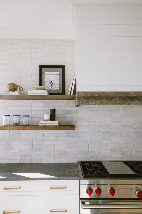 This warm wabi sabi kitchen with rugged concrete countertops and reclaimed floating shelves provides a warm and inviting feel Wabi Sabi Backsplash, Surf House Kitchen, Concrete Backsplash Kitchen, Shiplap Range Hood, Rustic Coastal Kitchen, Concrete Backsplash, Cement Countertops, Westerly Rhode Island, Stone Backsplash Kitchen