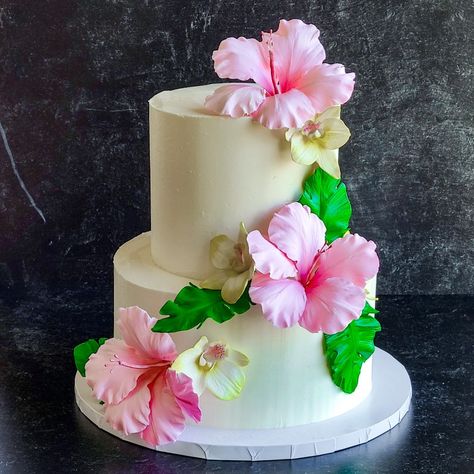 Three tier buttercream wedding cake decorated with sugar hibiscus, orchids and palm leaves Hibiscus Wedding Cake, Hibiscus Cake Decoration, Tropical Cake Ideas, Hibiscus Flower Cake, Tropical Flower Wedding, Hawaiian Theme Cakes, Luau Centerpieces, Hibiscus Cake, Tropical Cakes