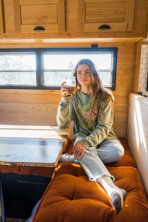 Shelby sits down in her vintage camper while she sips on her coffee in front of a beautiful view of pines trees and mountains. The camper is redone with beautiful warm tones and she wears an outfits by Volcom women's new Earth Tripper collection. She rocks a loose fitting long sleeve teeshirt in olive green with the words "Volcom Stone" written in pink with botanical designs framing the text. She wears light washed jeans with fringe at the bottom. Granola Girl Style, Van Life Aesthetic, Granola Outfits, Best Granola, Surf Swimwear, Mountain Aesthetic, Granola Girl Aesthetic, Surfing Swimwear, Her Outfits