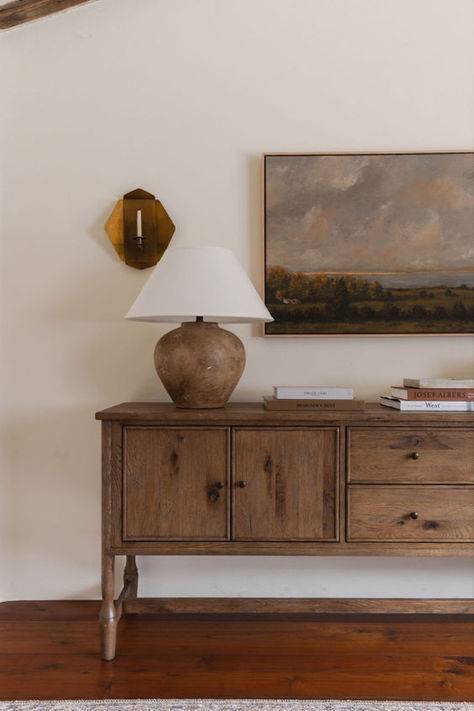 Discover the epitome of chic with Amber Lewis's impeccably styled wood sideboard. Adorned with an oversized table lamp, curated books, and a stunning frame, this piece exudes timeless elegance. Elevate your interior design game with this effortlessly stylish addition to your home decor. #AmberLewis #HomeDecor #InteriorDesign #WoodSideboard #StylingInspiration #ChicDecor #HomeStyling Amber Interiors Entryway, Made For Living Amber Lewis, Amber Interiors Lamp, Amber Lewis Landscape, Amber Lewis Vase, Amber Glass Table Lamp, Sideboard Styles, Entryway Style, Modern Vintage Decor