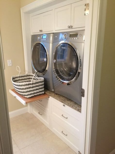 Enclosed Washer and Dryer  |  Laundry room features built-in cabinets encasing a silver front-load washer and dryer accented with pull out trays sandwiched between cabinets above and stacked drawers below. Transitional Laundry Room, Laundry Room/mud Room, Dream Laundry Room, Laundry Room Remodel, Laundry Closet, Small Laundry, Laundry Room Storage, Laundry Mud Room, Laundry Room Makeover