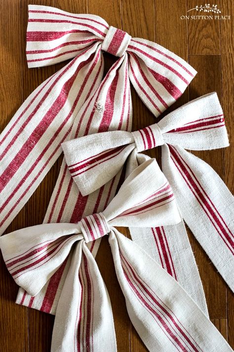 Easy step-by-step directions for making a grain sack ribbon bow from an antique grain sack or other fabric. No machine sewing required! Fabric Christmas Bows Diy, Sew Fabric Bows, Cloth Ribbon Bow How To Make, Fabric Bows Pattern, Sewing Project Christmas, Christmas Sewing Projects Easy, Sewing Project For Gifts, How To Make A Bow Out Of Fabric, Sewing Ribbon On Fabric