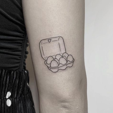 Egg carton or egg tray tattoo inked above the right elbow by @hellotako Cracked Egg Tattoo, Deviled Egg Tattoo, Egg Tattoo Ideas, Ignorant Tattoo Ideas, Easter Egg Tattoo, Fried Egg Tattoo, Egg Tattoo, Cooking Tattoo, Above Elbow Tattoo