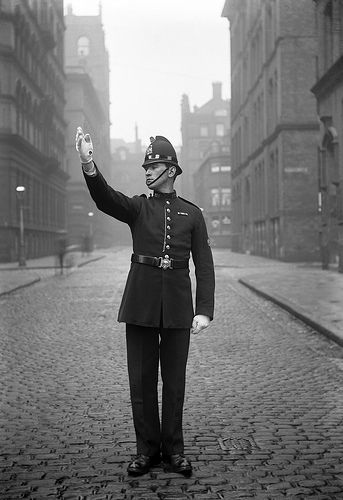 A wonderfully preserved image of a Manchester City Police officer on point duty in central in the city around 1914.    Before the electronic traffic light became widespread, officers would control junctions during busy periods. This practice was known as point duty and each officer would be allocated a ‘point’ and set times at which he was to attend. http://www.gmpmuseum.com 1930s Police Uniform, 1930s British Fashion, Victorian Police Uniform, 1920s Police Officer, British Police Officer, British Police Uniform, Victorian Policeman, Constable Police, The 39 Steps