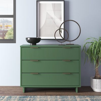 With its ribbed drawer front and clean lines, this versatile dresser adds a touch of modern glam to your bedroom, home office, or guest room. The spacious frame is made from solid and engineered wood in the finish of your choice, and it rests on sled-style legs for a mid-century silhouette. This dresser comes with three drawers with metal, gold-finished handles that reveal room for everything from clothes and linens to toys and books. We love that the surface is just right for a table lamp and a Dresser Green, Refurbish Ideas, Retro Dresser, Bedroom Revamp, Dresser Wood, Green Dresser, Black Dressers, Solid Wood Dresser, 3 Drawer Dresser