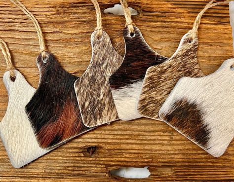 Cowhide ccow tag ornaments Set of 6  You get 6 cowhide ornaments , cut from genuine Real cowhide measuring shape cattle ear tag 3.0 / 3.0 mixed colors of cut from genuine cowhide color selections, no repeats in your set.  Lassoed with   jute twines.  Do you have an event or an ornament exchange tradition with your family? These will be perfect for and rustic tree, or home with Western Christmas tree decor.  Homestead farmer gifts. mix and match with leather ornaments from our other collections!! Cowhide Ornaments, Homestead Farmhouse, Western Christmas Decorations, Boho French Country, Cowhide Christmas, Leather Ornaments, Tag Ornaments, Western Christmas Tree, Cowhide Decor