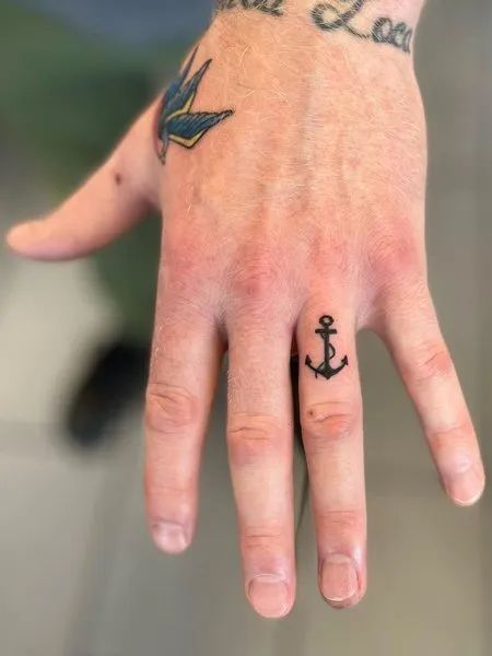 70+ unique and striking finger tattoo designs: symbols, hennas, roses, snakes, dots, lettering, hearts, and wedding rings for couples. Bonus: tattoo meanings. Anchor Finger Tattoo Men, Tattoo Designs Men Finger, Anchor Tattoo On Finger, Anchor Tattoo On Hand, Anchor Tattoo Hand, Anchor Finger Tattoos For Women, Anchor Hand Tattoo Men, Finger Anchor Tattoo, Anchor Hand Tattoo