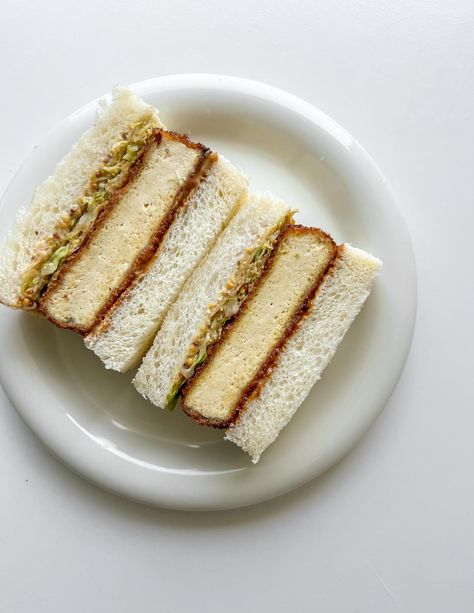 The Tofu Katsu Sando features a crispy breaded tofu cutlet, fresh cabbage, and tangy-sweet tonkatsu sauce between soft shokupan bread, offering a flavorful plant-based twist on a classic Japanese sandwich. Perfect for a quick, healthy meal, this vegan sandwich is both satisfying and easy to make. Shokupan Bread, Tofu Katsu, Katsu Sando, Japanese Sandwich, Breaded Tofu, Tofu Sandwich, Japanese Milk Bread, Specialty Sandwiches, Tonkatsu Sauce