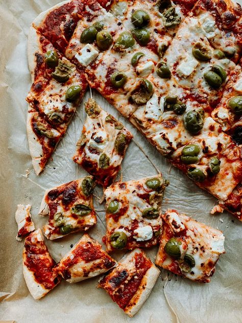 This pizza is topped with crushed Castelvetrano green olives, creamy feta cheese, and a generous sprinkle of spicy red pepper flakes. | whipandwander.com | #pizzanight #pizzarecipe #homemadepizza #easypizzrecipes #pizzarecipes #vegetarianpizza #pizzatoppings #greenoliveandfetapizza #greenolivepizza #fetapizza Feta Pizza, Olive Pizza, Gluten Free Pizza Dough, Reheat Pizza, Meat Pizza, Creamy Feta, Classic Pizza, Gluten Free Pizza, Green Olives