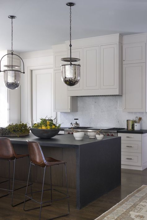 Modern sculptural pendants draw the eye to a beautiful dark island and leather seating. Slc Interiors, Glass Upper Cabinets, Dark Island, Hamptons Kitchen, Art Deco Kitchen, Marble Countertops Kitchen, Barn Kitchen, Black Kitchen Island, Rustic Flooring