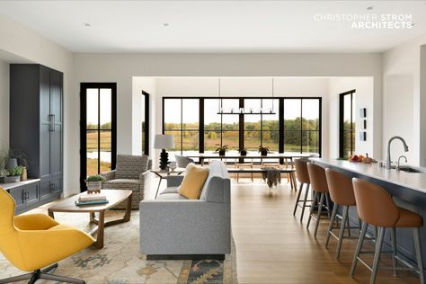 Modern Farmhouse Kitchen with white cabinetry, navy island, white stone countertop, brown leather stools, light blue tile backsplash, and a hidden butler's pantry. The custom CSA-designed home, called “Eye-land,” is named for the natural beauty of the prairie landscape. The home is located in White Oaks Savanna, which is a “unique, design-driven community with 30 home sites nestled into the lush prairie landscape” located minutes from Downtown Stillwater. Modern Prairie Home, Andersen Doors, Modern European Home, Hinged Patio Doors, Prairie Landscape, Modern Prairie, Exterior Color Palette, Impact Doors, Prairie Home