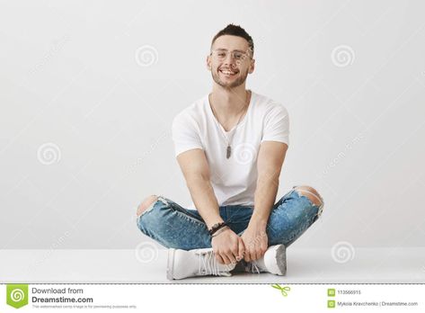 Cute and trendy boyfriend in glasses sitting on floor with crossed legs, holding hands on feet, smiling broadly at. Photo about confident, background, emotional, casual - 113566915 Leg Reference, Guy Sitting, Sitting On Floor, Sitting Cross Legged, Cross Legged, Drawing Body Poses, Man Sitting, Human Poses Reference, Human Poses