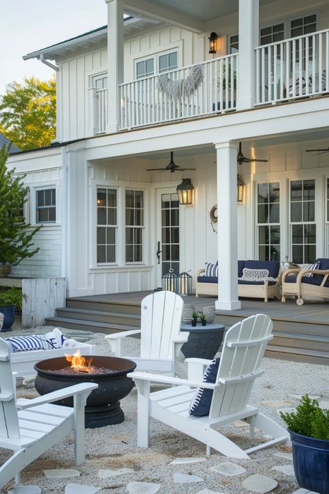 Click to see more outdoor patio ideas! This coastal-themed patio with Adirondack chairs, a fire pit, and nautical decor accents offers a relaxed seaside vibe. It’s a perfect spot for enjoying the coastal atmosphere at home. Coastal Farmhouse Backyard, Coastal Back Porch, Coastal Fire Pit, Coastal Deck Ideas, Patio With Adirondack Chairs, Beach House Deck, Coastal Backyard, Tropical Patio, Farmhouse Backyard