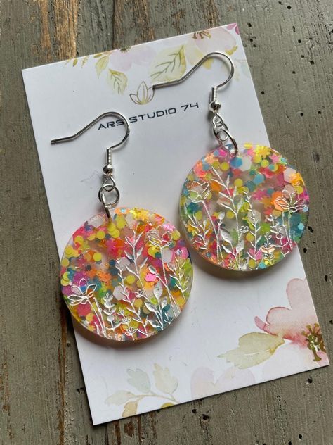 Handmade floral meadow round flowers resin earrings, on hoops or ear hooks. Bespoke, unique jewellery These gorgeous earrings are made of resin with multicolour glitter and handpainted on flower engraving. The finish is on gold plated hoops or silver (25mm diameter) or simple gold plated or silver ear hooks. Hand Painted Resin Earrings In Artsy Style, Round Resin Flower Earrings, Multicolor Resin Earrings, Nature-inspired Handmade Resin Earrings, Nature-inspired Resin Earrings For Gifts, Mustard Seed Jewelry, Handmade Rakhi, Homemade Clay, Resin Jewelry Making