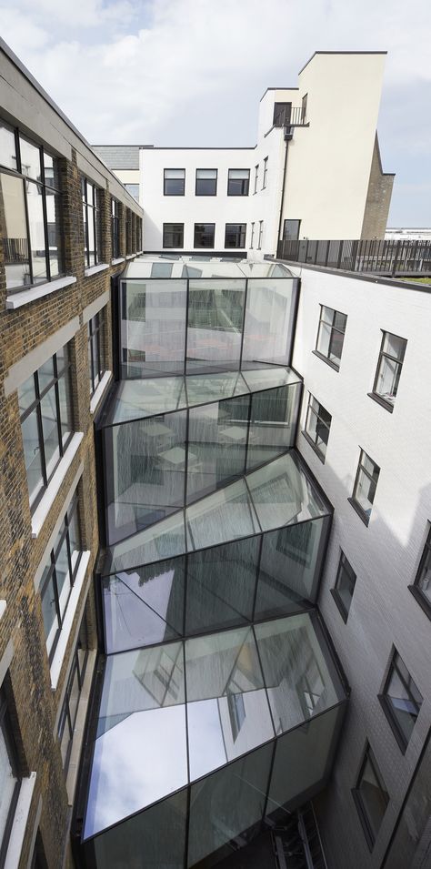 The unique new atrium on this office development provides a physical link between an old building, built in 1904 as Marks and Spencer’s HQ, and its 1936 addition. With glass walls on each level set at different planes, every step taken through the building promises a completely different aspect. A truly dynamic space. #architecture #england #glazing #rural #extension #cantifix Old Building With New Addition, Building Addition Architecture, Architecture Between Buildings, Architecture Extension Projects, Old Building Extension, In Between Spaces Architecture, In Between Space Architecture, Building Extension Architecture, Dynamism Architecture